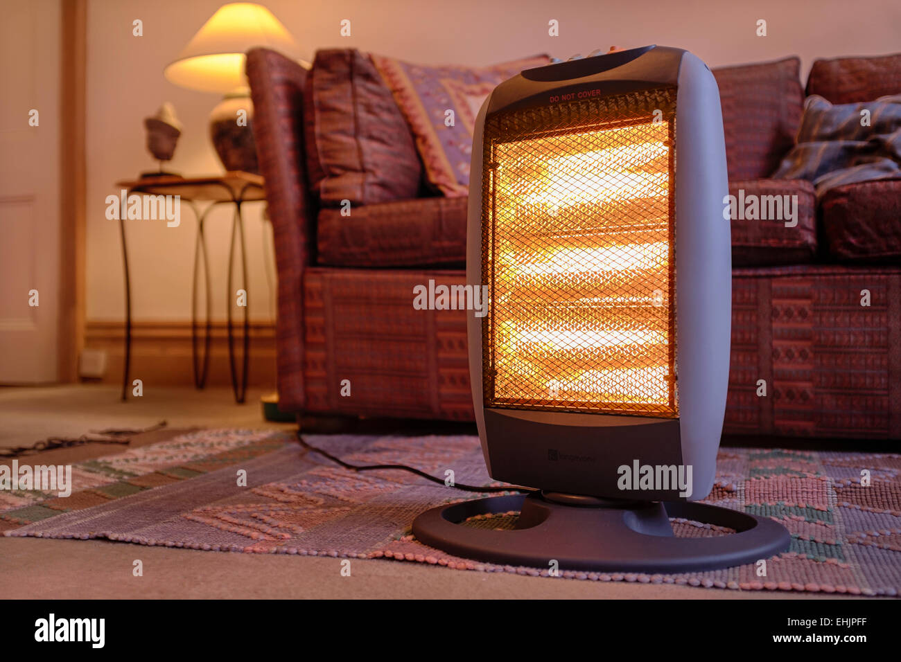 Calefactor halógeno eléctrico portátil en el interior del hogar. Foto de stock