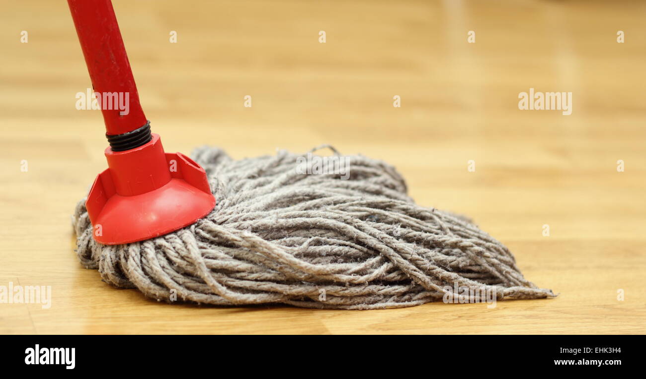 un limpiador con uniforme rojo limpia el suelo con la ayuda del vapor que  sale de la boquilla de la escoba eléctrica Fotografía de stock - Alamy