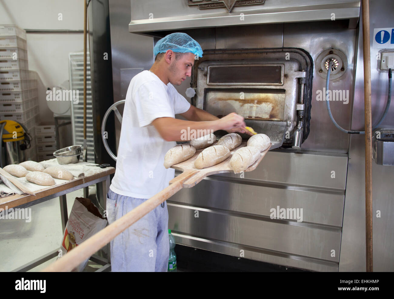 Panadero trabajando preparando horno para hacer pan fotografías e