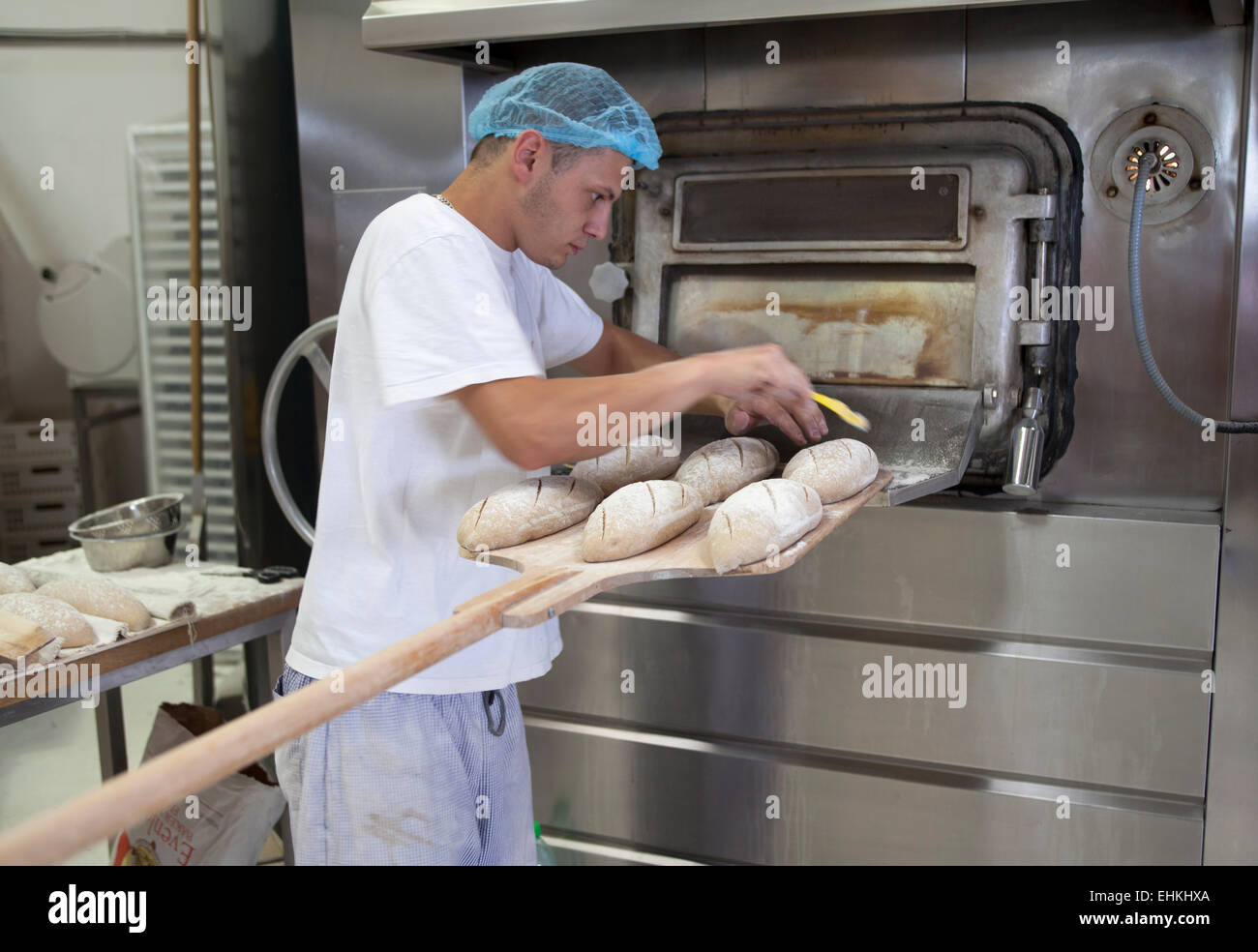 Panadero trabajando preparando horno para hacer pan fotografías e
