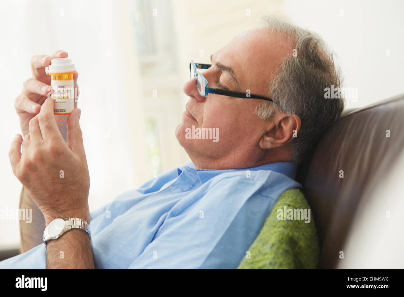 Hombre hispano frasco de medicamentos de prescripción de lectura Foto de stock