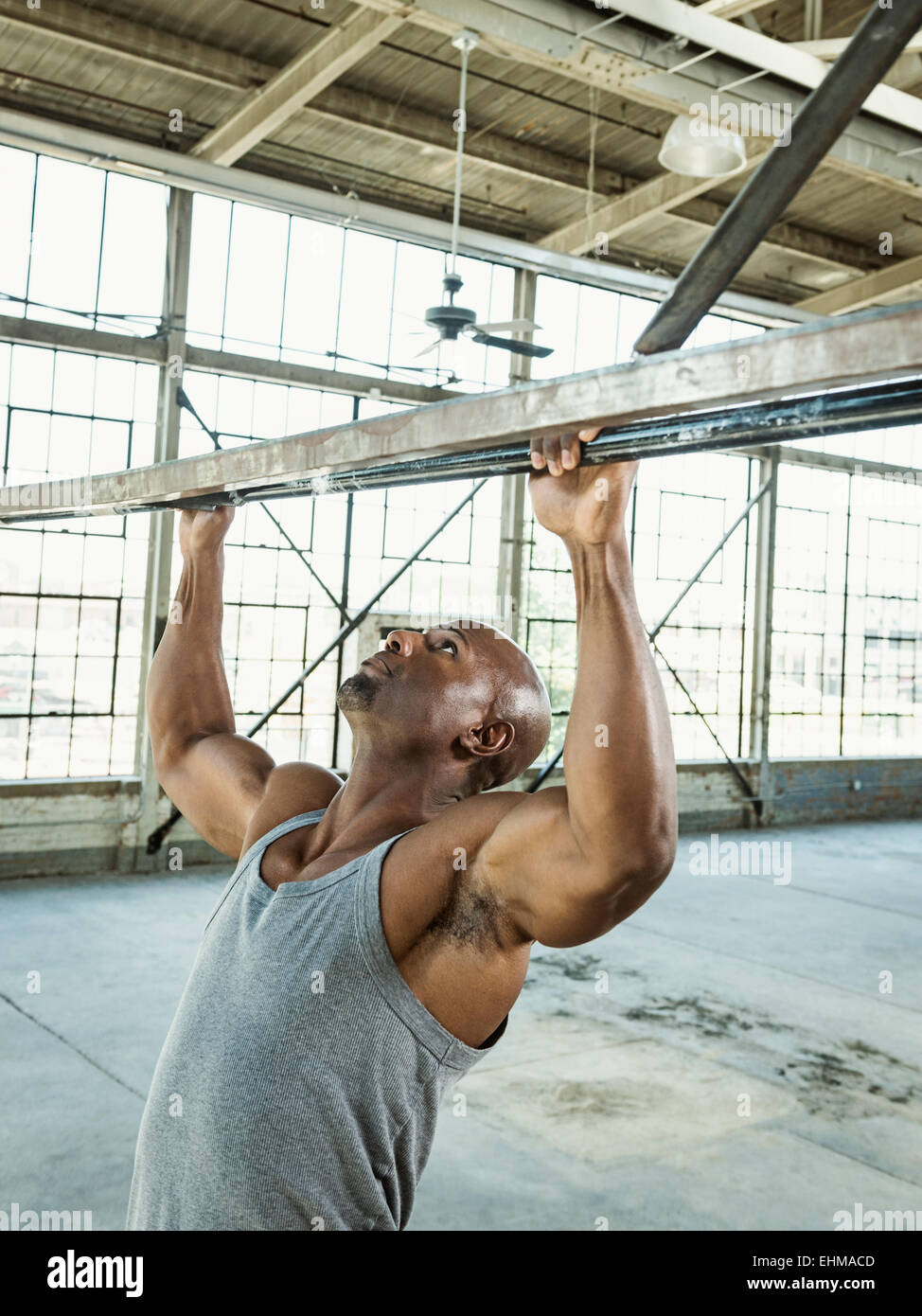 Hombre Negro haciendo pull-ups en el almacén Foto de stock