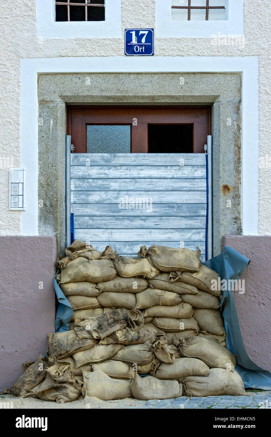 Medidas de control de inundaciones, sacos de arena y un muro protector de listones de acero delante de una puerta delantera, el centro histórico, Passau Foto de stock