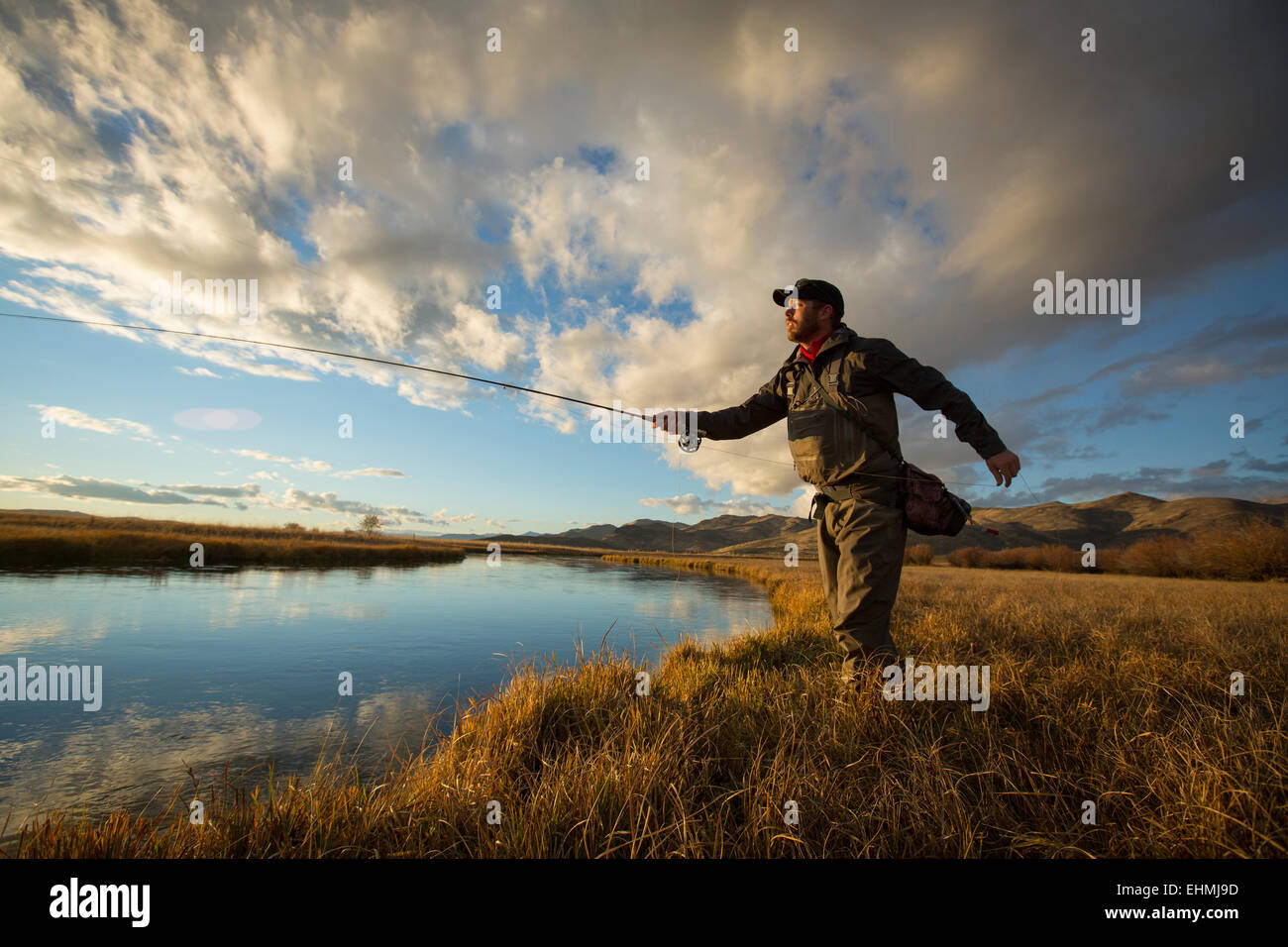 Fundición de pescador en el río. Foto de stock