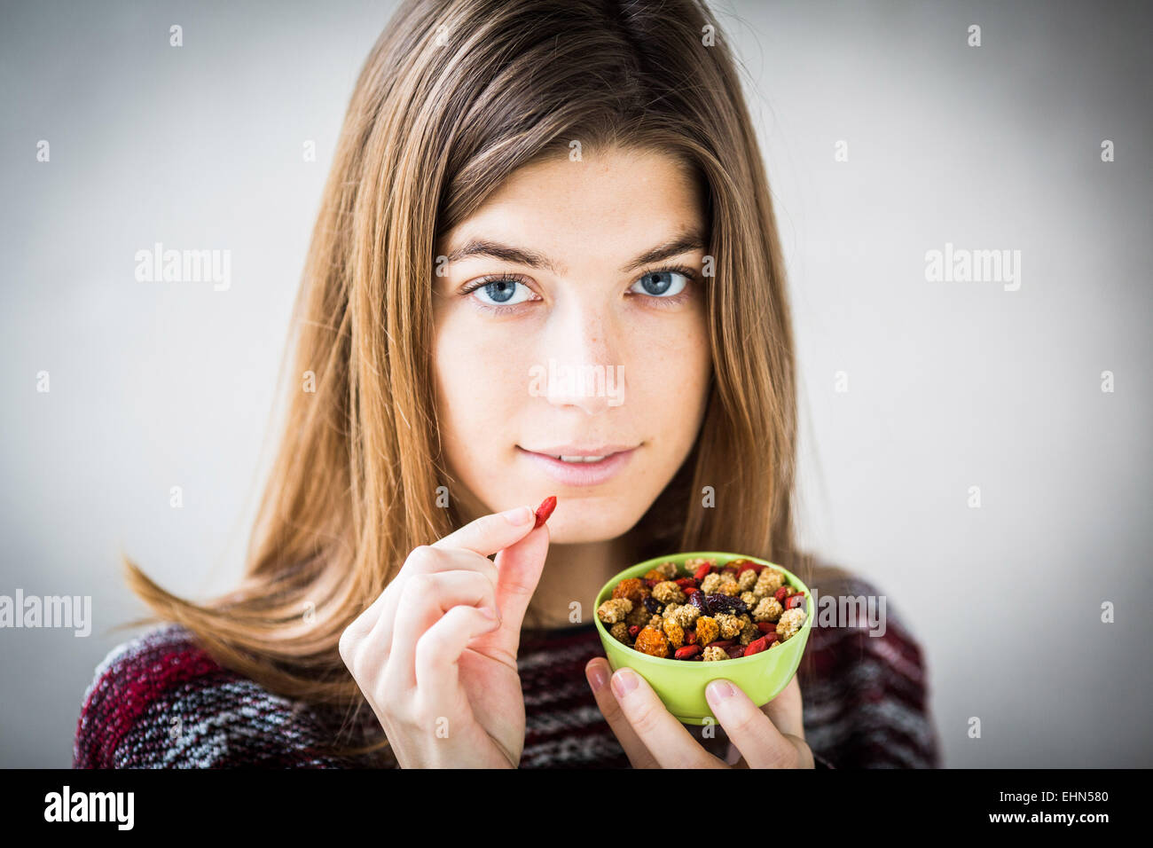 Mujer comer varias tuercas. Foto de stock