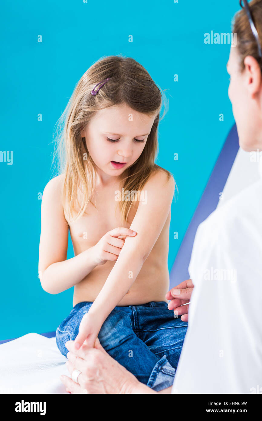 El pediatra examina la piel de una niña de 4 años. Foto de stock
