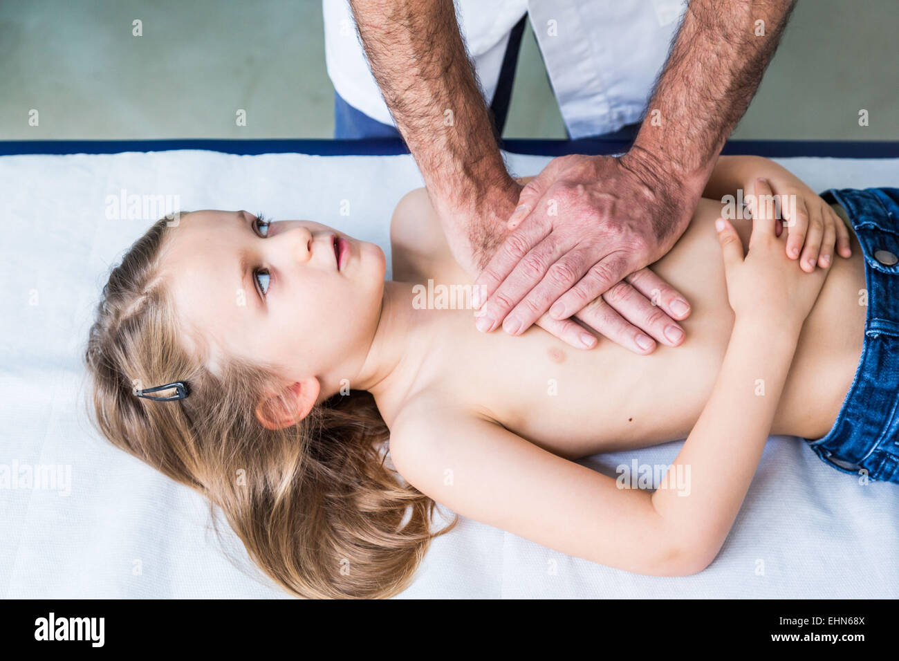 Médico realiza fisioterapia respiratoria en un niño de 4 años. Foto de stock