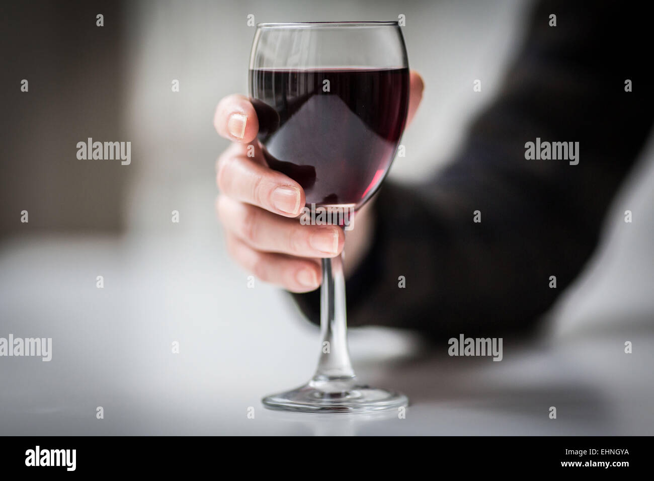 Mujer sosteniendo un vaso de vino tinto. Foto de stock