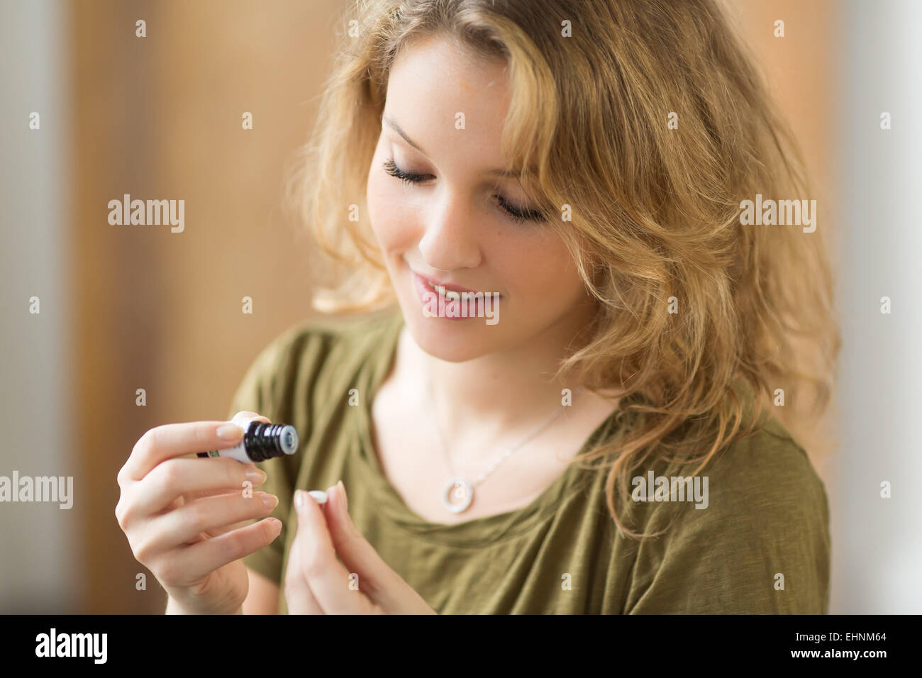 Mujer aplicar aceite esencial sobre una píldora neutral. Foto de stock