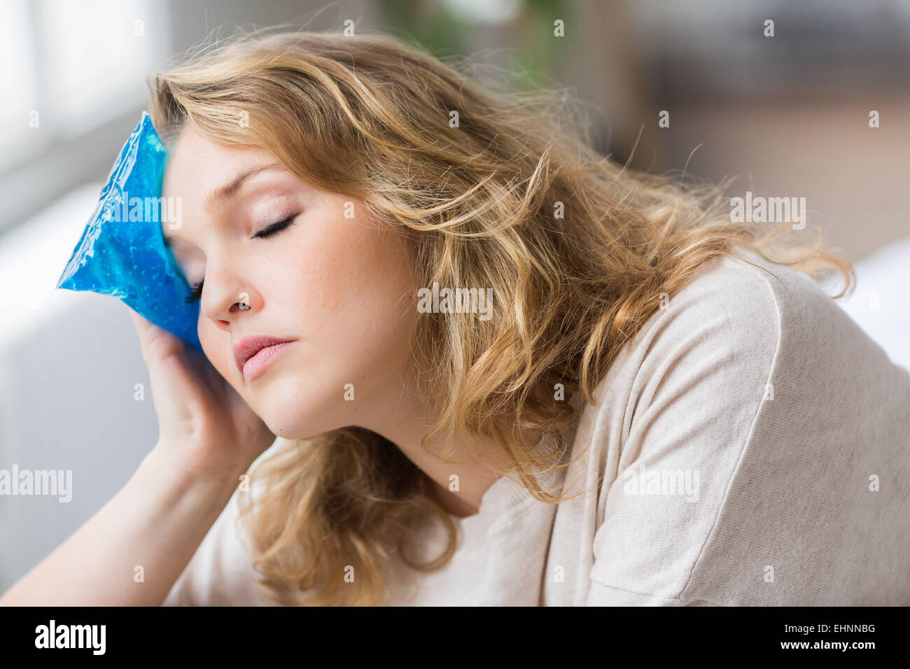 Mujer con un gel frio-calor pack tratamiento para releive dolor. Foto de stock