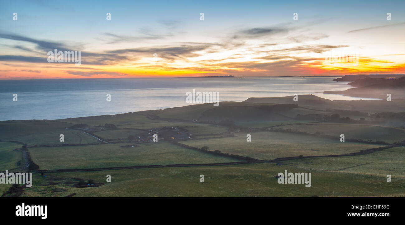 Colorido atardecer en la Costa Jurásica de Dorset con campos y bay Foto de stock