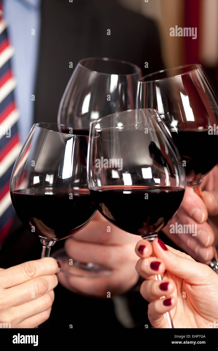 Celebrando y brindando con copas de vino tinto Fotografía de stock - Alamy