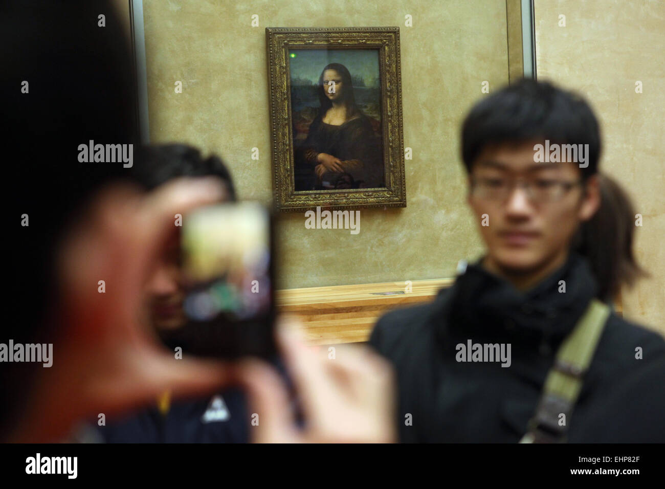 Los visitantes tomar fotos en frente de la 'Mona Lisa' ('La Gioconda') por Leonardo da Vinci. Museo del Louvre, París, Francia. Foto de stock