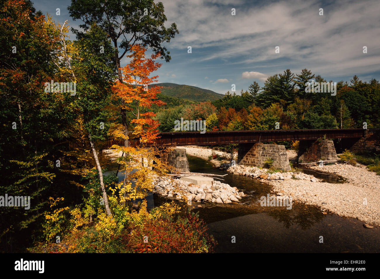 Puente del ferrocarril sobre un río y colores del otoño cerca de Bethel, Maine. Foto de stock