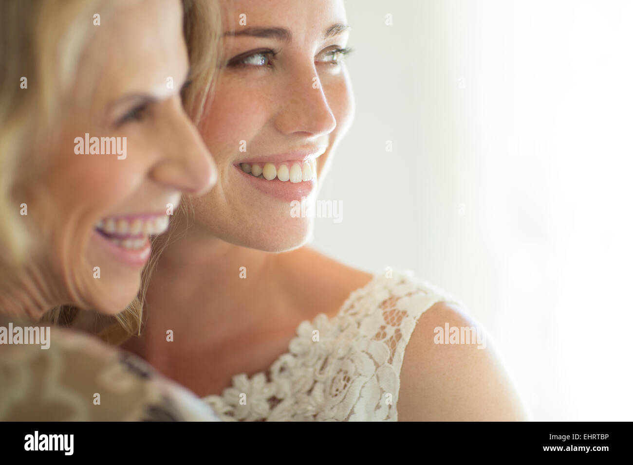 La matrona del honor y la novia sonriendo en la sala interna Foto de stock