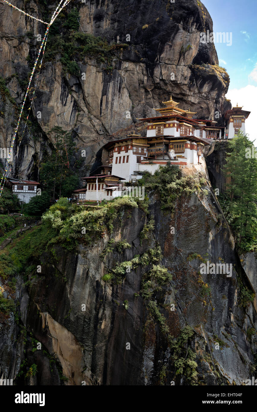 Bután - Taktshang Goemba, (The Tiger's Nest el monasterio), situado en el lado de un alto acantilado sobre el paro del valle del río. Foto de stock