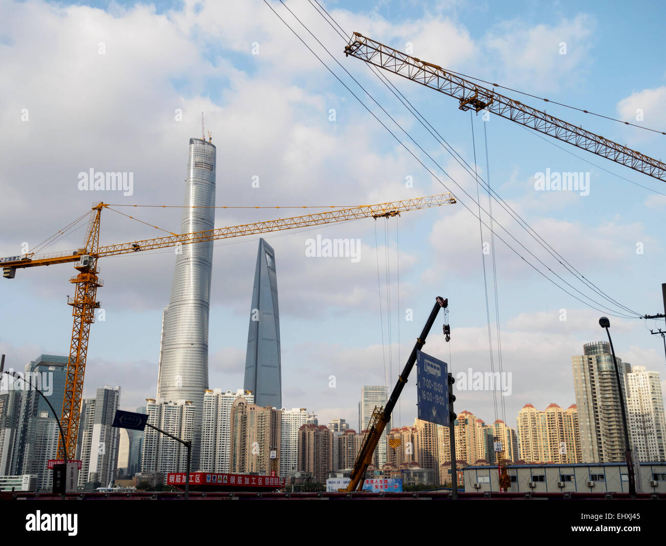 Grúas de construcción en frente de la torre de Shanghai y el rascacielos del Centro Financiero Mundial de Shanghai, China Foto de stock