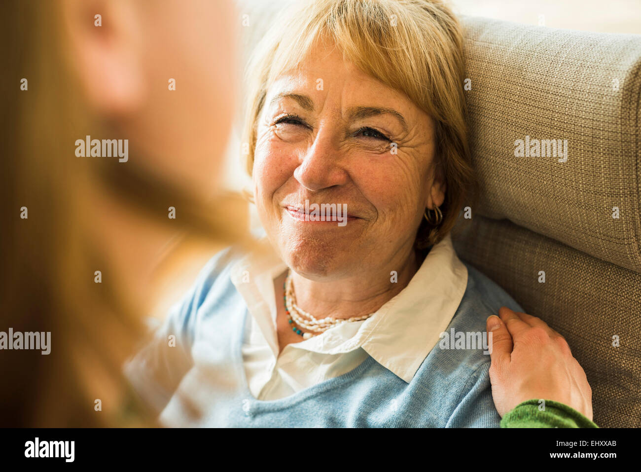 Abuela sonriendo mirando nieta de adultos Foto de stock