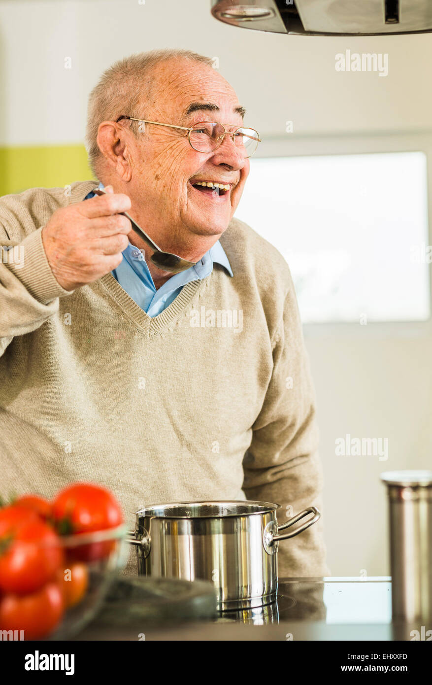 https://c8.alamy.com/compes/ehxxfd/feliz-el-hombre-senior-degustacion-de-olla-en-la-cocina-ehxxfd.jpg