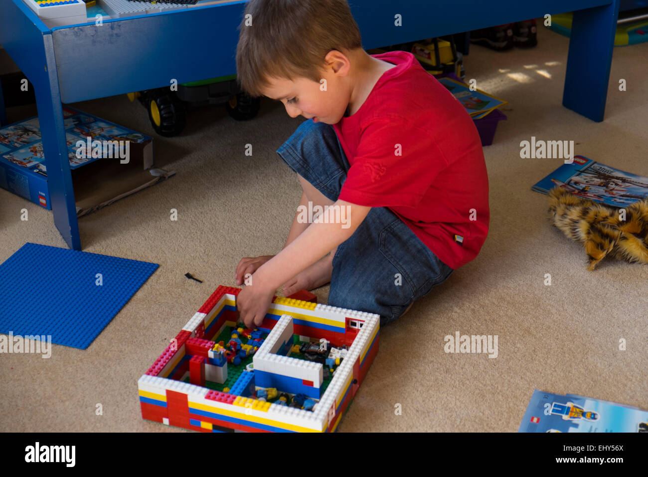 Niño de cuatro años de edad jugando con bloques de construcción Lego en dormitorio Foto de stock