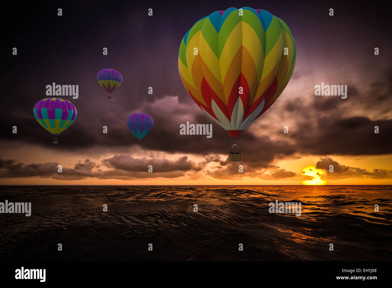 Coloridos globos de aire caliente en la puesta del sol sobre el mar Foto de stock