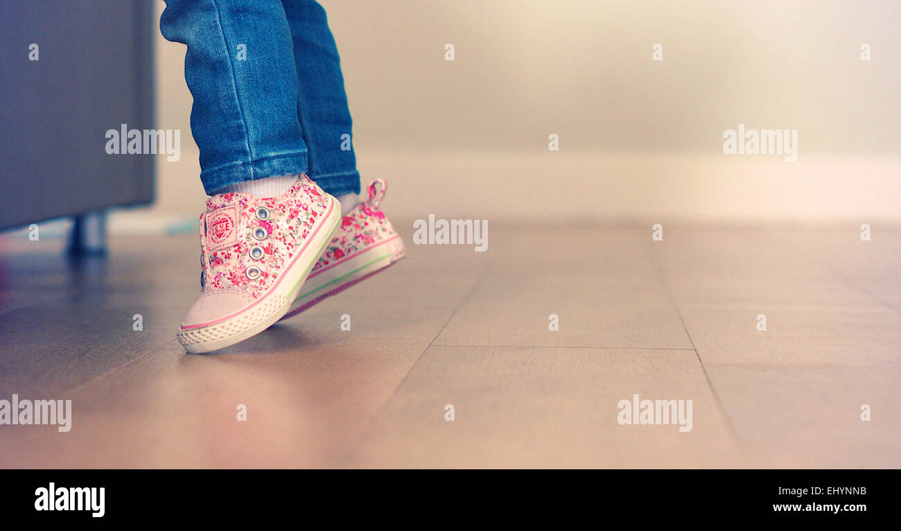 Niña aprendiendo a pararse sobre sus pies Foto de stock