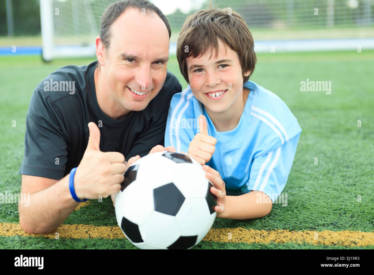 Un joven jugador de fútbol con el balón en el campo Foto de stock