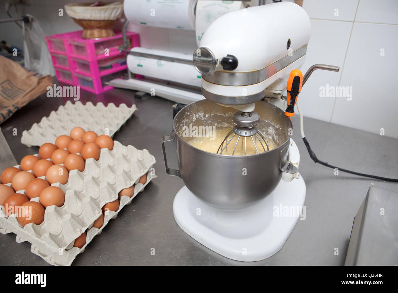 Batido misa en la confitería de la máquina. Proceso de fabricación de madeleines español Foto de stock