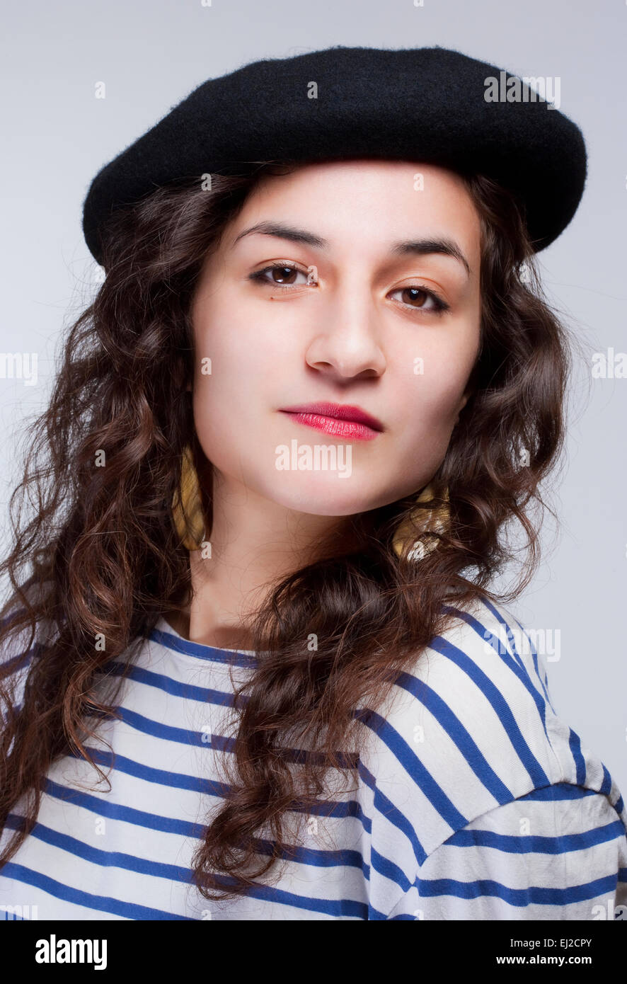 Retrato de una mujer joven con Barrett sombrero y camiseta de rayas Foto de stock