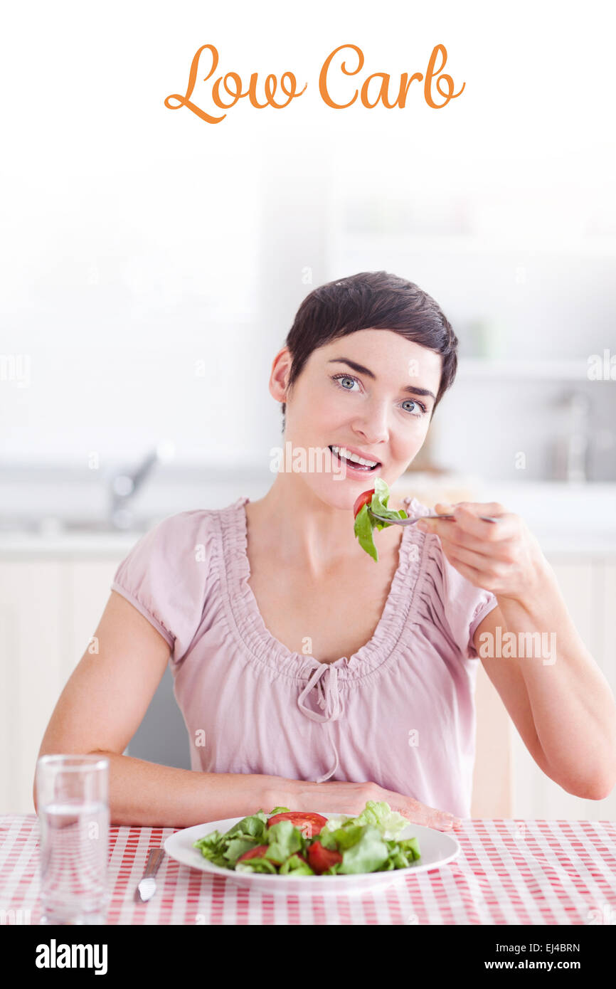 Low Carb contra alegre mujer morena comer ensalada Foto de stock