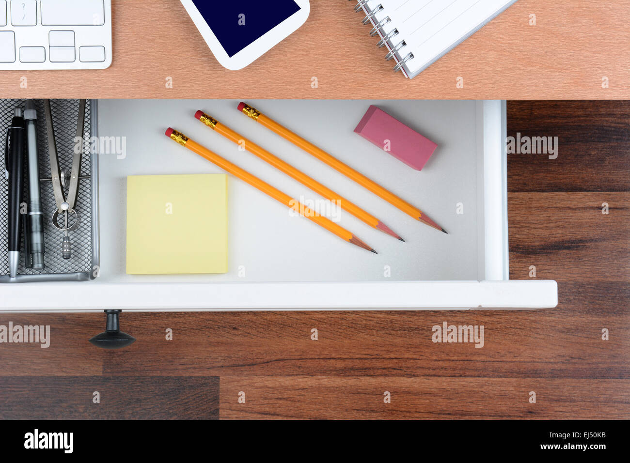 Un alto ángulo de disparo de un cajón de escritorio abierto, mostrando los elementos en su