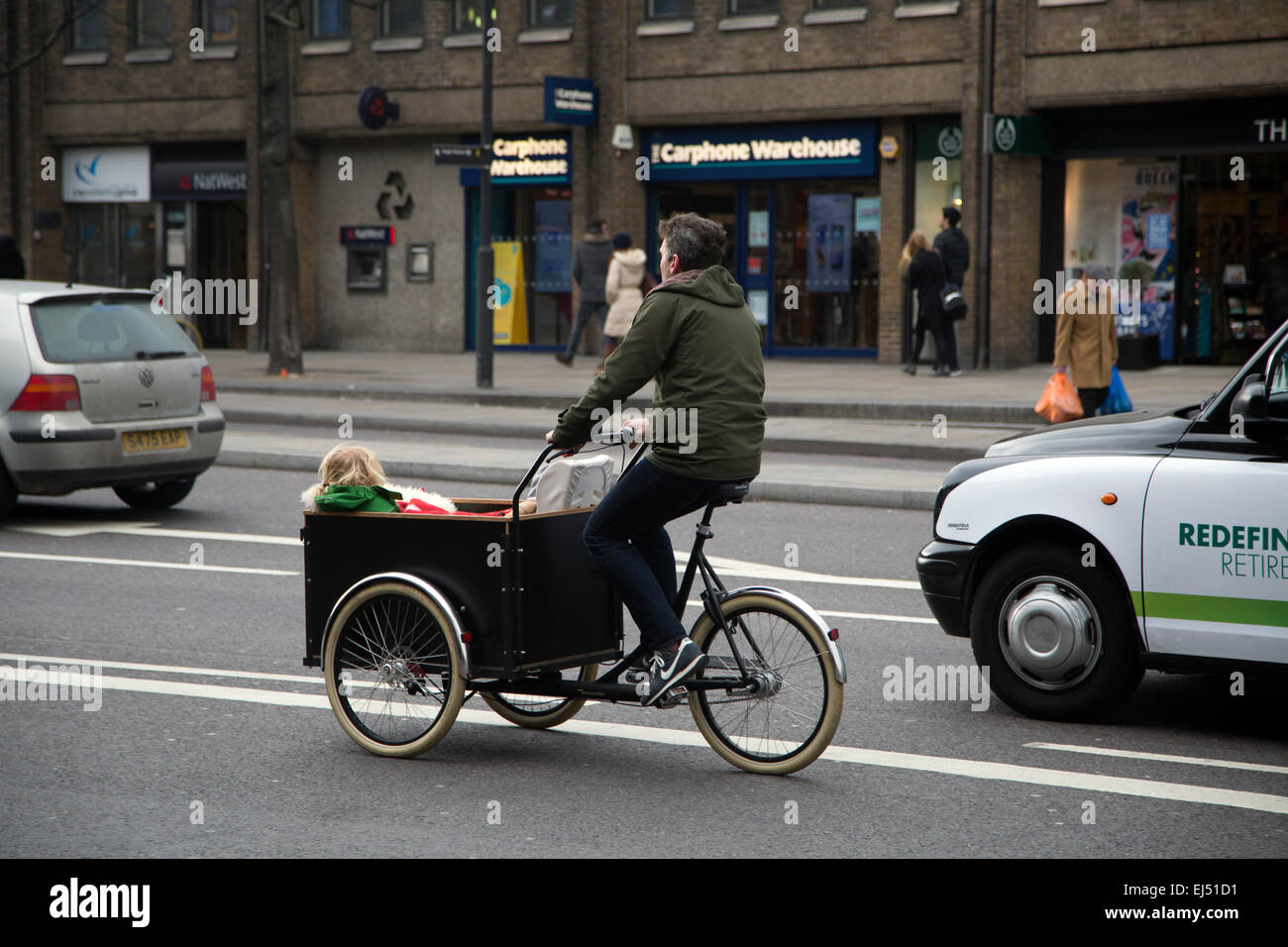 El hombre llevando a los niños a la escuela en bicicleta Foto de stock