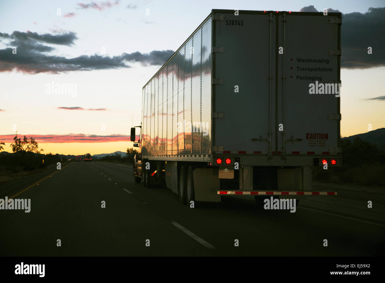 18-wheeler semi-Truck lleva hacia el oeste por la Interstate 10, cerca de Palm Springs, California, EE.UU. Foto de stock
