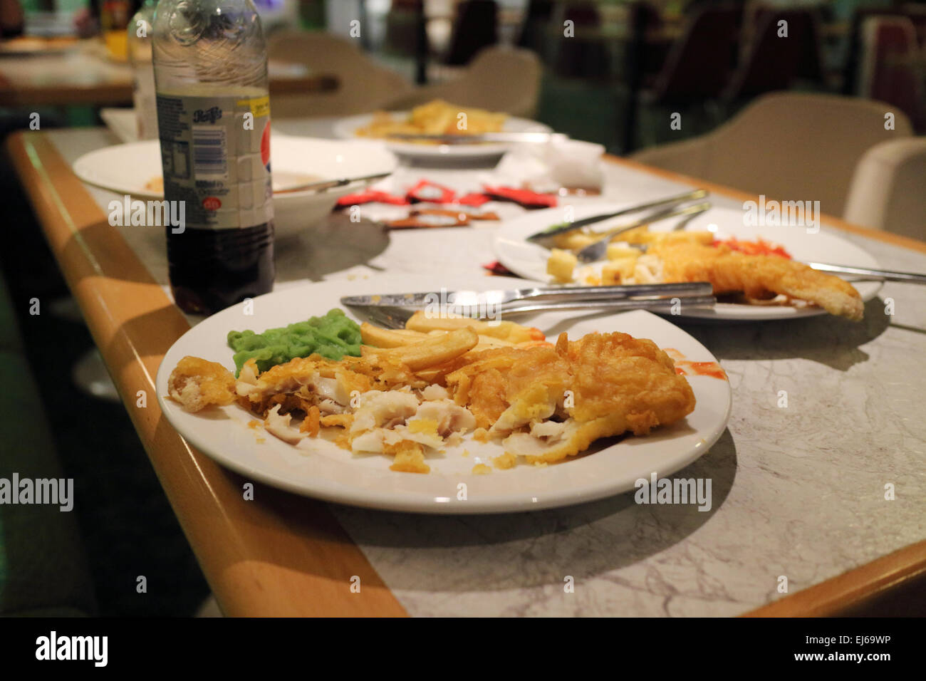 La mitad comido pescado y patatas fritas comidas en un café restaurante en el reino unido Foto de stock