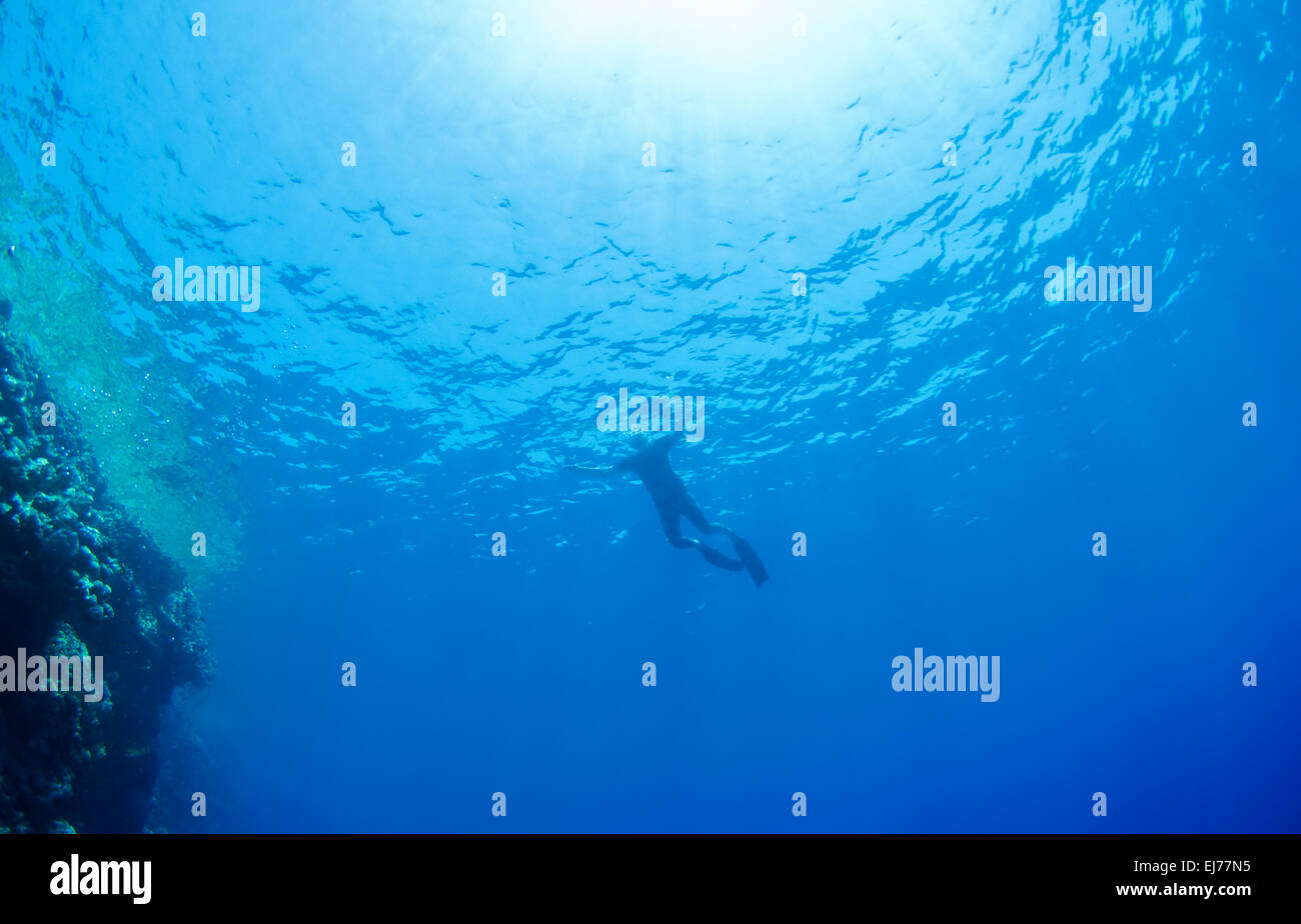 Snorkeling hombre, agua y rayos de sol. Foto de stock
