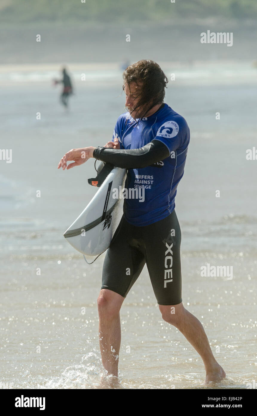 Pro Surfer compruebe el tiempo al final de la ronda en la implacable Boardmasters 2014, en Newquay's Fistral Beach Foto de stock