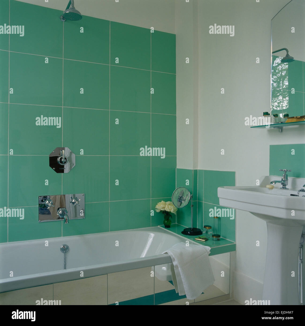 Pared de azulejos verdes sobre la bañera con ducha en cromo blanco moderno  cuarto de baño con lavabo de pedestal Fotografía de stock - Alamy