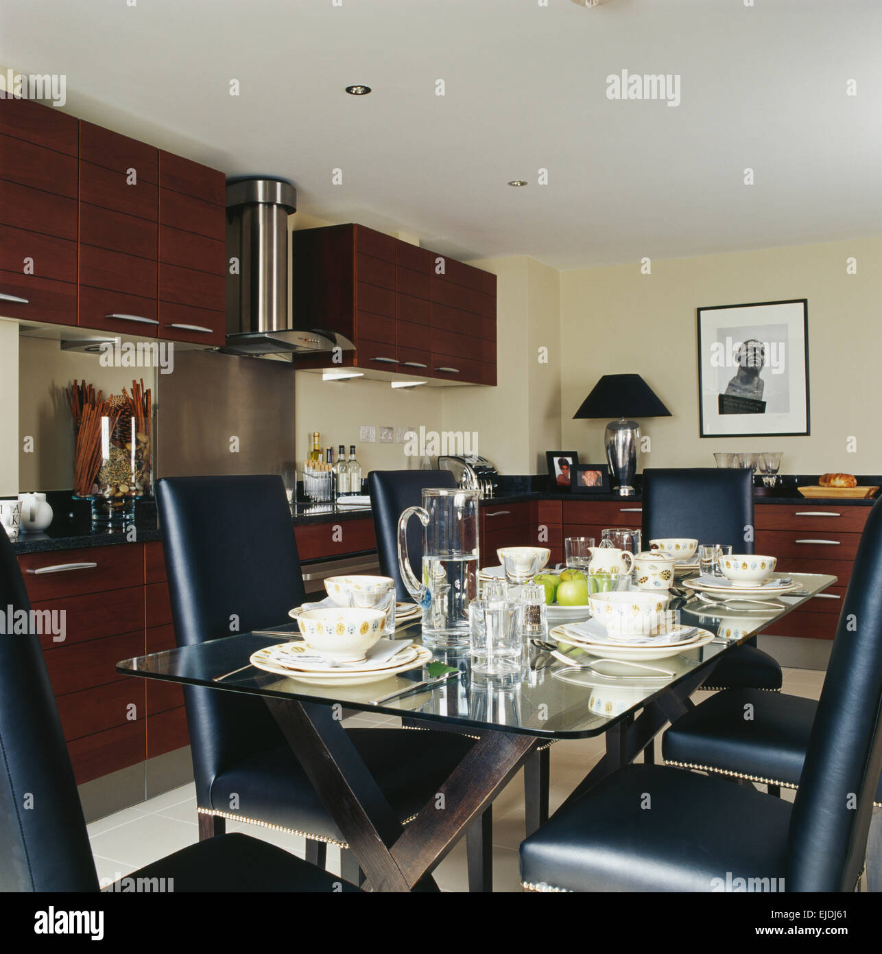 Sillas de cuero negro en vaso rematado mesa dispuesta para la cena en la  moderna cocina comedor Fotografía de stock - Alamy