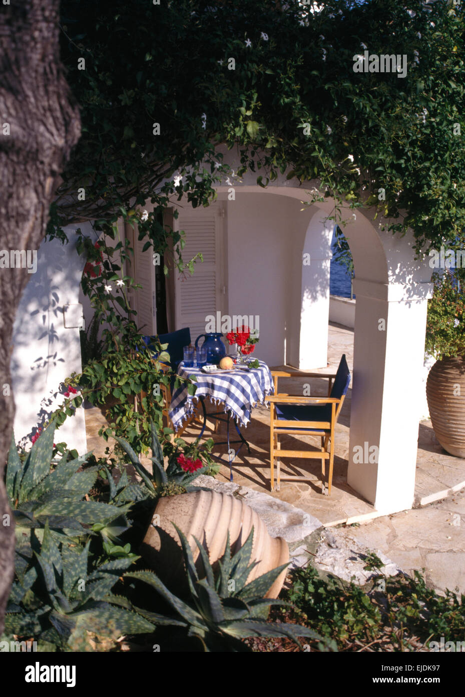 Villa en Corfu con sillas en la mesa establecida para un almuerzo en la  terraza alfresco Fotografía de stock - Alamy