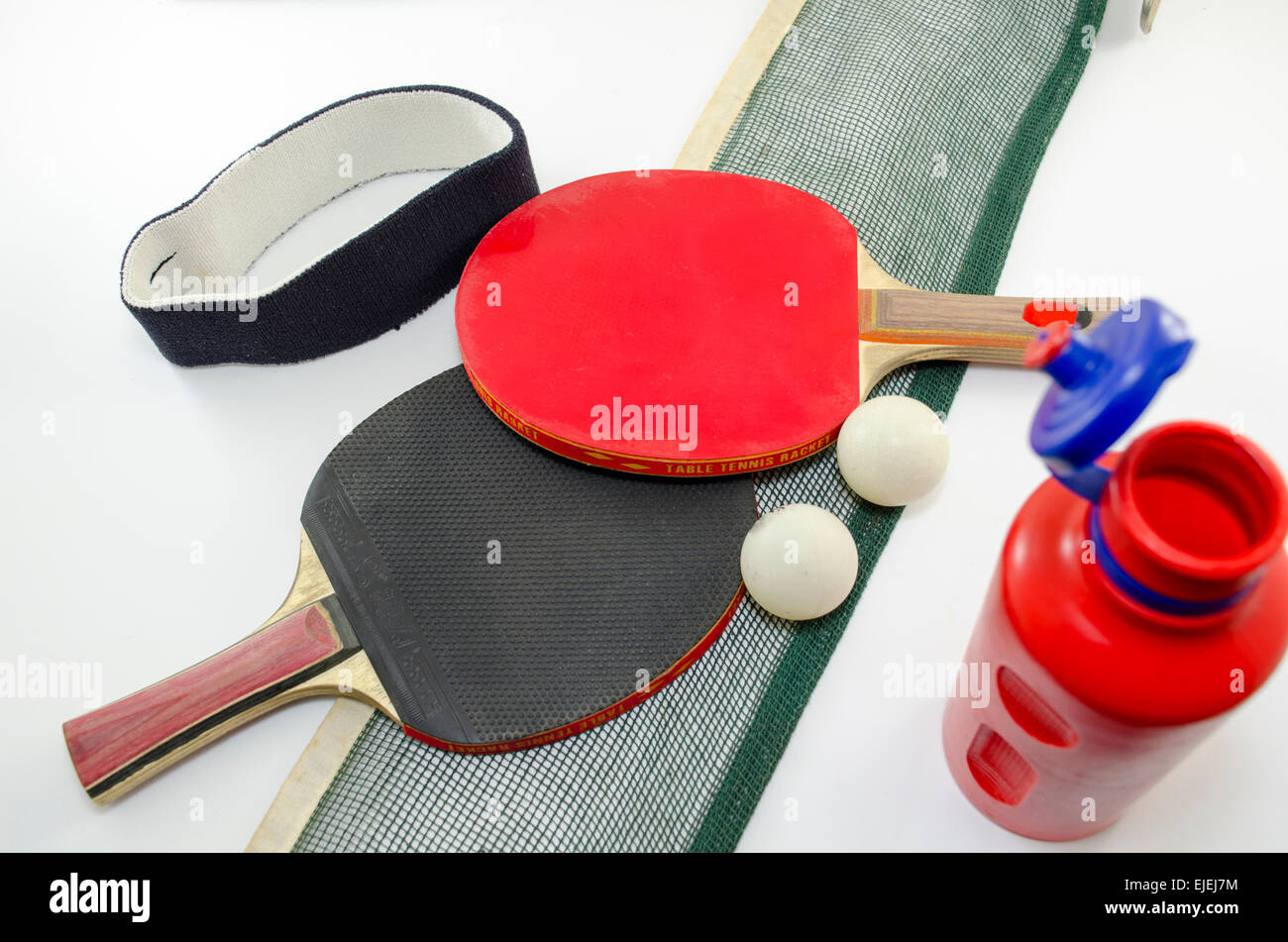 Dos raquetas de tenis de mesa y una vieja red aislado en blanco junto con  una cinta para la cabeza y una botella de agua de plástico Fotografía de  stock - Alamy