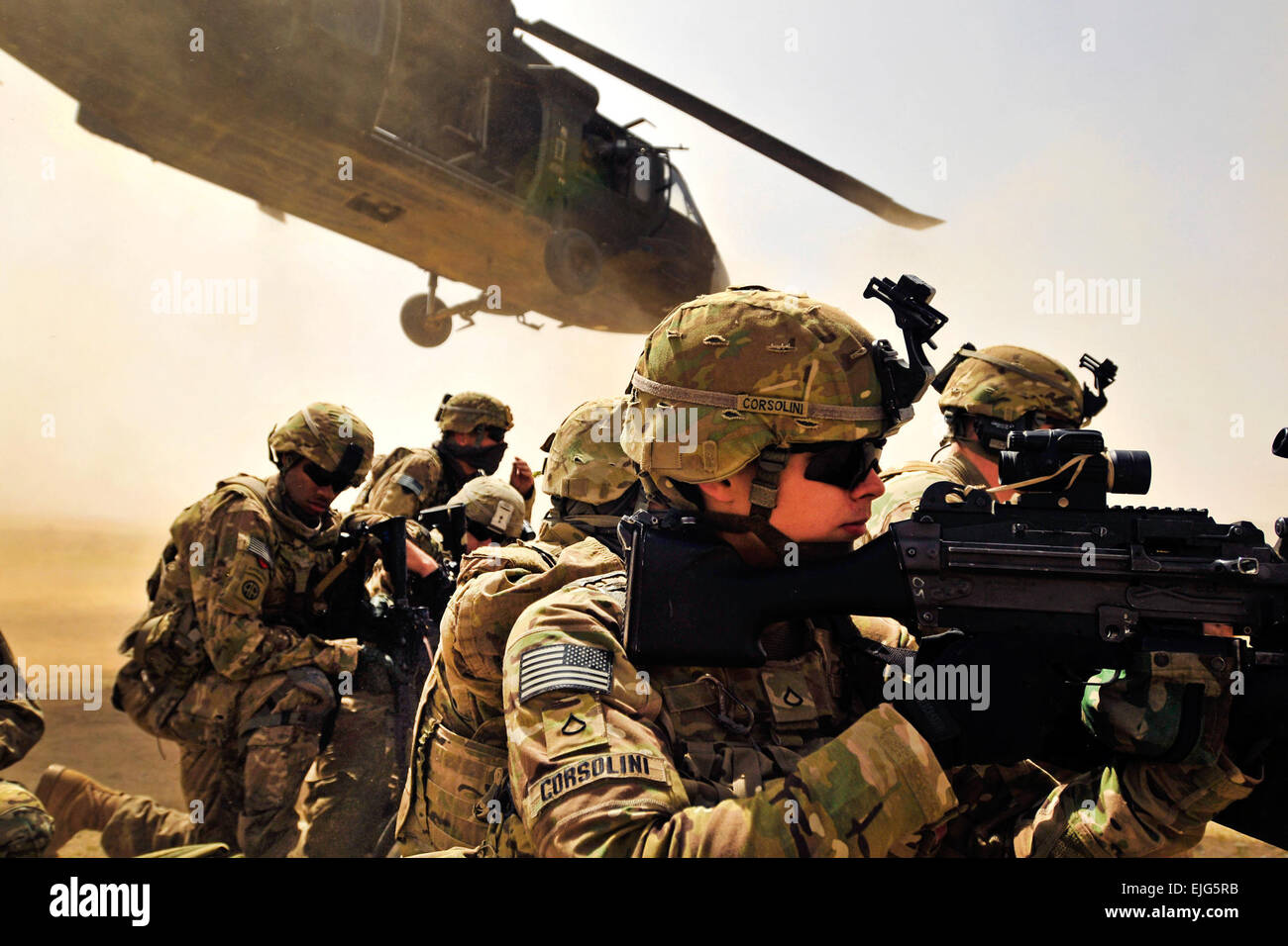 Pfc. Samuel Corsolini, 2º Batallón del 25º Regimiento de Aviación, la 25ª Brigada de Aviación de Combate, tira de la seguridad con otros conquistadores como un helicóptero Black Hawk UH-60 despega tras la descarga a su equipo y a los miembros de 2º Orden Civil Nacional Afgano patrulla especial equipo de armas y tácticas en la provincia de Kandahar, Afganistán, 16 de marzo. Foto de stock