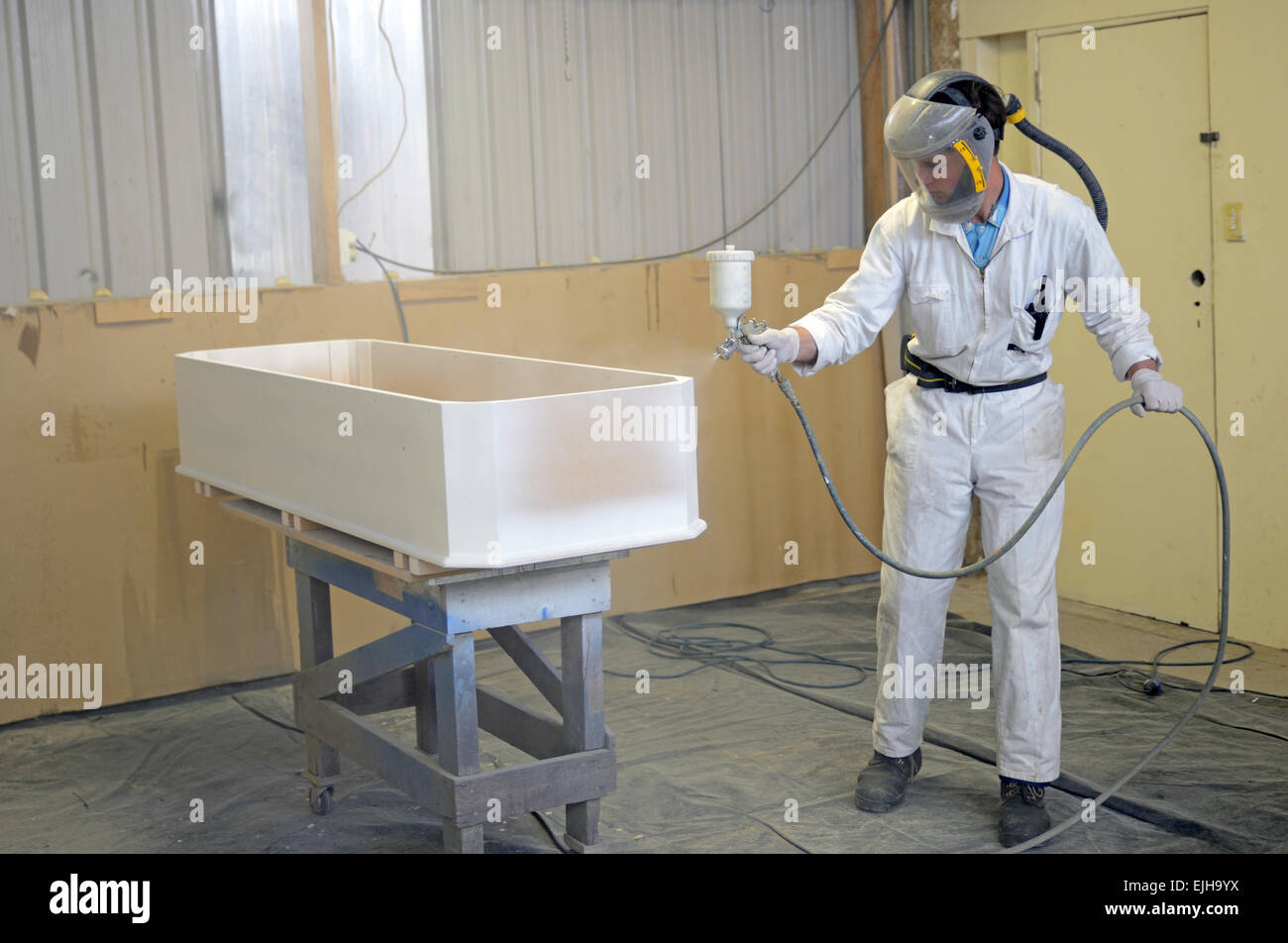 Un comerciante Barnicez Spray un ataúd en una cabina de pulverización Foto de stock