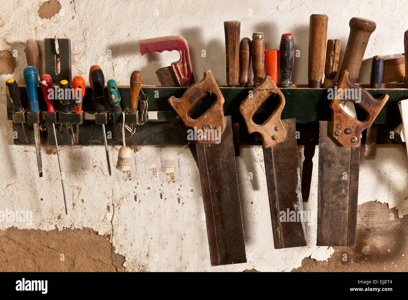 Conjunto de viejas sierras de mano colgando de un estante en la pared  Fotografía de stock - Alamy