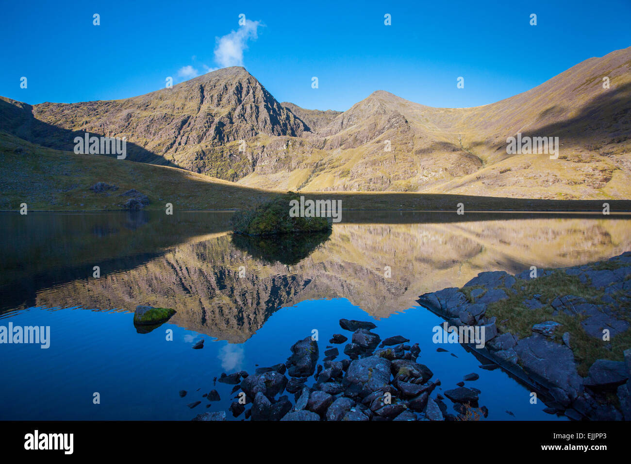 Y Carrauntoohil Beenkeragh reflejado en Lough Callee, Hag's Glen, MacGillycuddy's Reeks, en el condado de Kerry, Irlanda. Foto de stock