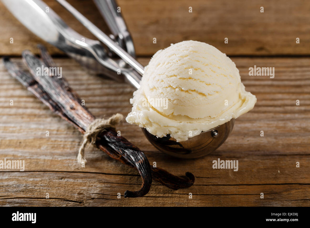 Bola de helado de vainilla con una cuchara scoop Foto de stock
