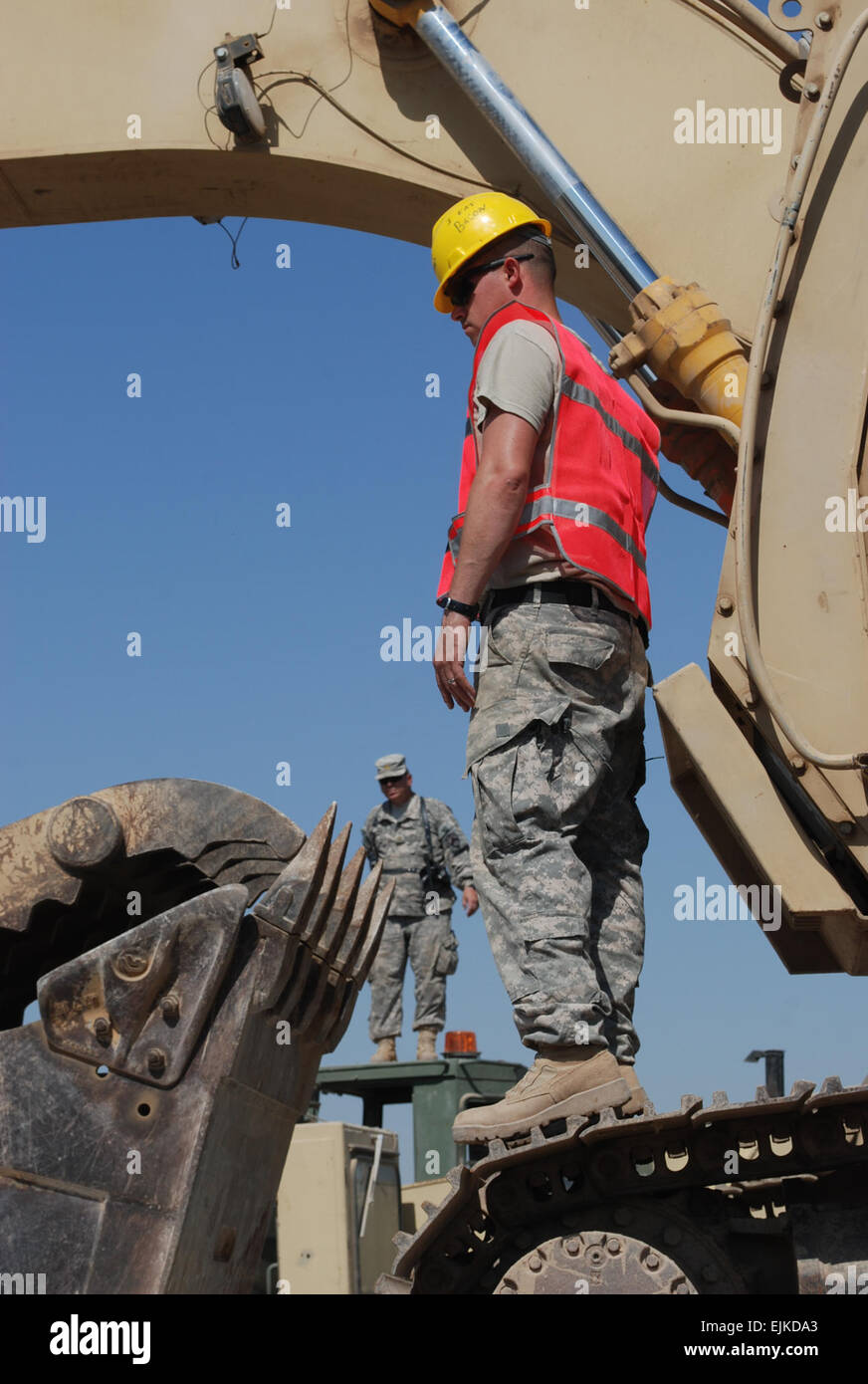 El Sgt. Darryl libera, 402ª Brigada de Soporte de Campo del Ejército,  inspecciona su trabajo después de cargar una excavadora en un camión en el  campamento Libertad, Iraq. Libera es parte de