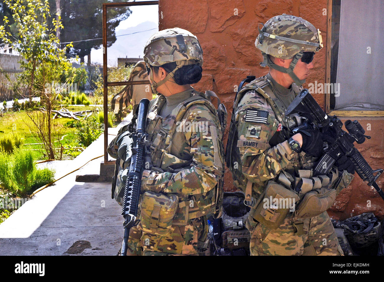 Ejército de EE.UU. Pvt. 1St Class Jo Marie Rivera, a la izquierda, un especialista en recursos humanos, y el sargento. 1St Class Rebecca Hamby, un policía militar, tanto con el equipo de combate de la Tercera Brigada, mantener la seguridad para un acoplamiento hembra jefe de equipo durante una consulta en una clínica en el distrito de Jaldak Tarnak wa, provincia de Zabul, Afganistán, el 18 de septiembre de 2013. El Sgt. Kandi Huggins Foto de stock