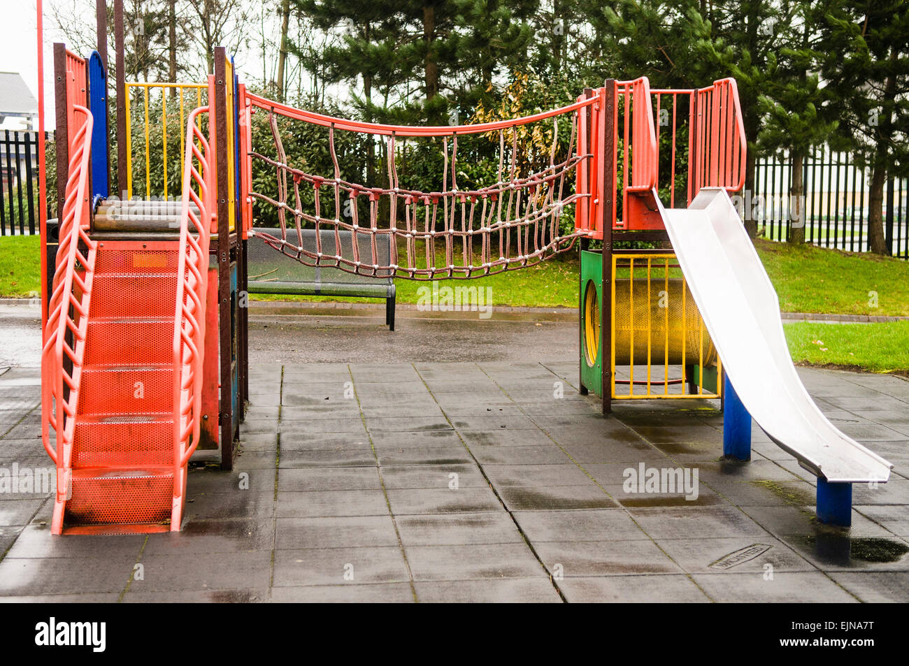 Parque infantil con columpio para bebés y deslice cerca de casas Fotografía  de stock - Alamy