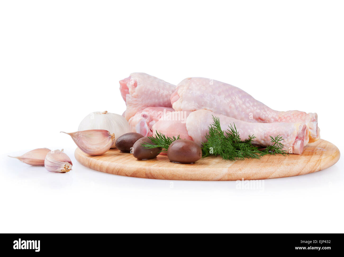 Las materias las patas de pollo con aceitunas y ajo sobre una tabla de madera Foto de stock