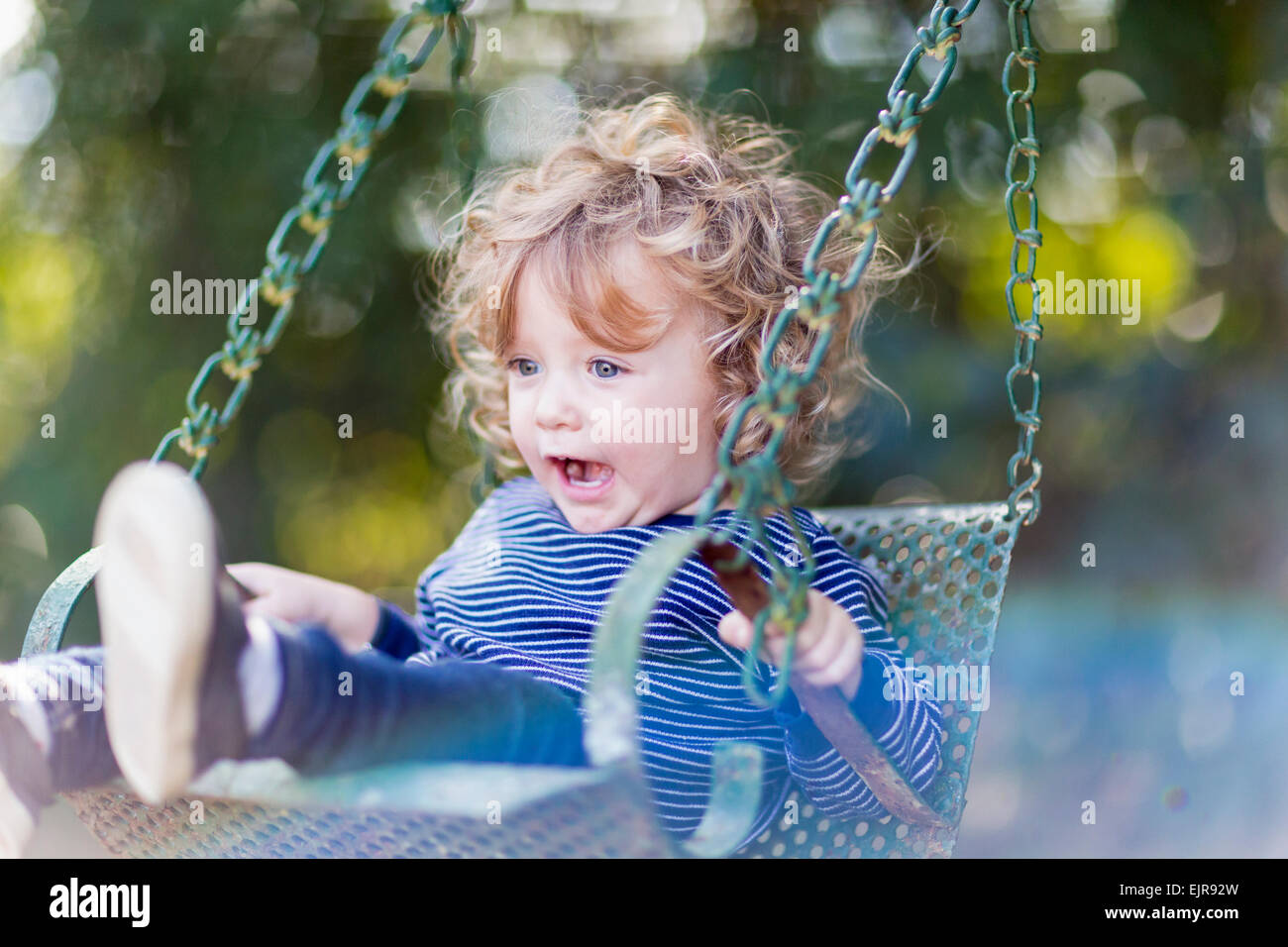 Caucasian Baby Boy sentado en swing Foto de stock